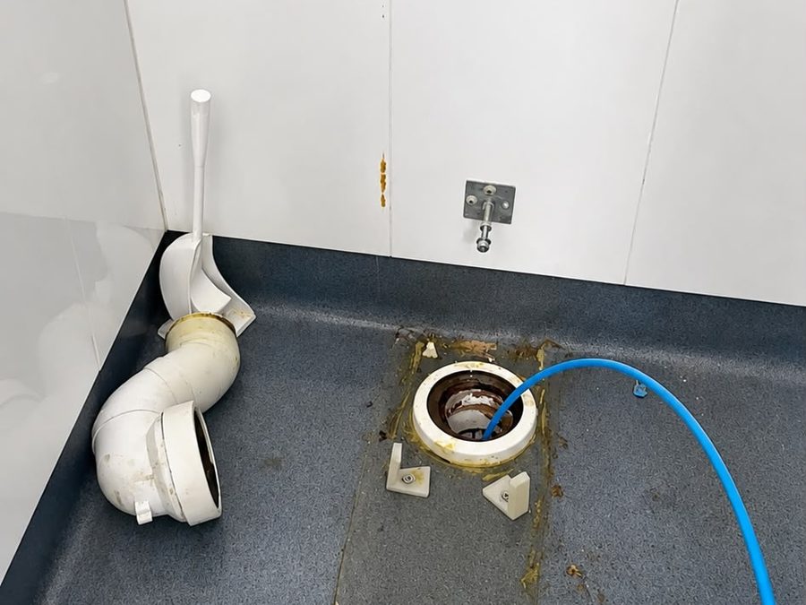 High-pressure drain cleaning set up at an internal floor waste in a Melbourne property