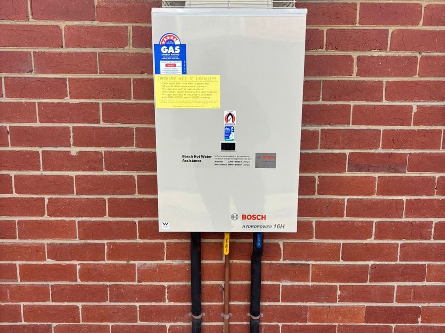Bosch gas hot water system installed on an exterior brick wall